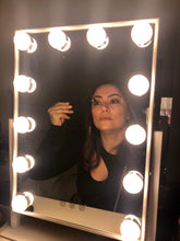 Load image into Gallery viewer, HOLLYWOOD VANITY MIRROR - This sturdy tabletop mirror features a white metal frame, 12 LED lights with 3 color temperature options, 360 degree tilt, and high clarity glass that offers an extremely vivid reflection | 3 COLOR TEMPERATURES - Lighting is dimmable and can be switched between cool white, warm white, and natural so you can create the perfect light setting for your makeup routine! | 360° ANGLE ADJUSTABLE - The mirror can be rotated 360 degrees to the exact angle needed. It has a stable,