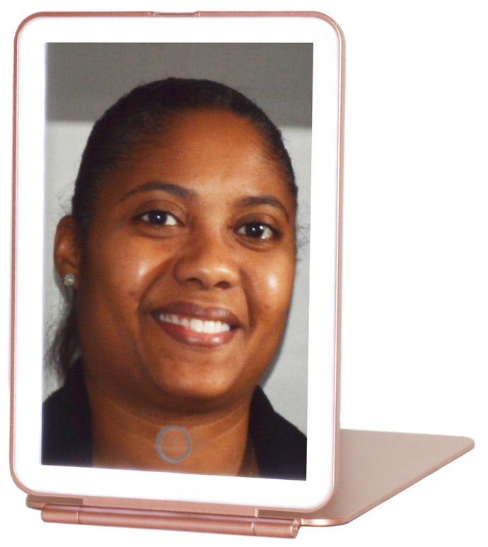 Portable handheld Rose Gold travel mirror with brightness adjustable LED lighting and 3 color settings (cool white, warm white, and natural). A simple touch of the sensor creates the perfect light setting for your makeup routine! | Operating the LED lighting is simple — one tap of the sensor turns the light on and each additional tap cycles through the light colors. Press and hold the sensor to dim the brightness. | The lightweight and compact design makes this mirror your new travel buddy. Whet